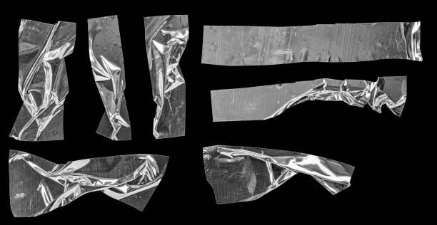 istock Metallic sticky teared tape shapes cuts isolated on black background. 1221216756