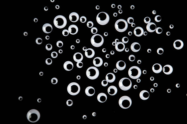 Top view of many googly eyes on black background