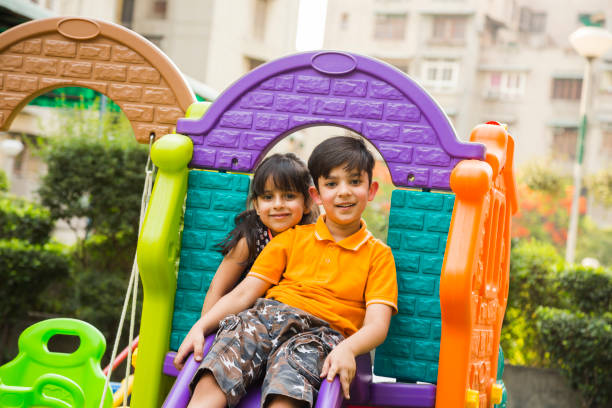Asian little boy and girl child with hand in hand while play together in the garden. Asian Children in green park