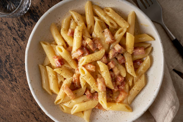 istock Carbonara pasta. Penne with pancetta, egg, parmesan cheese and cream sauce 1221224054