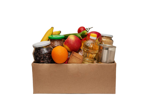 food donation box isolated on white background. open cardboard box with oil, canned food, cereals, vegetables and fruits. charitable donations for people in need. safe delivery during quarantine. - food donation box groceries canned food imagens e fotografias de stock