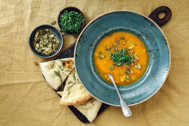istock Vegan Pumpkin and Carrot Soup on yellow tablecloth 1221225635