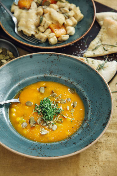 istock Vegan Pumpkin and Carrot Soup on yellow tablecloth 1221225705