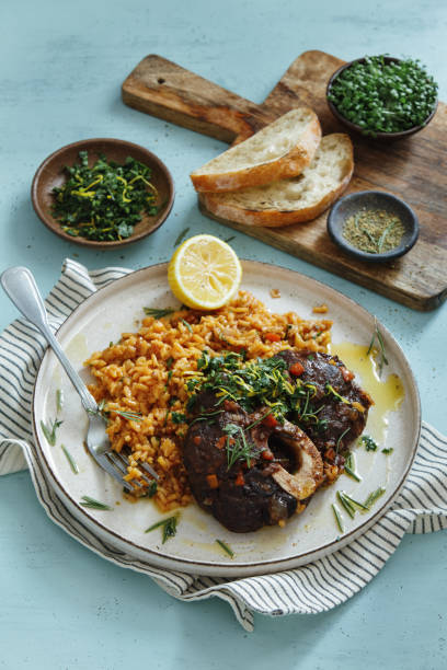 tradicional italiano osso buco com risoto de açafrão cremoso e gremolata - veal meat osso buco beef stew - fotografias e filmes do acervo