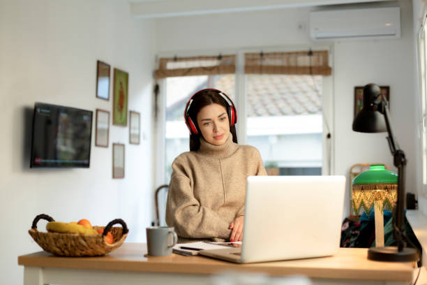 istock Happy young woman working from home on a laptop 1221227109