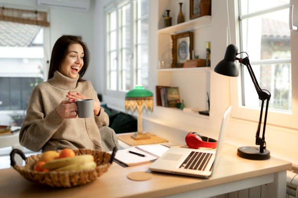 istock Smiling young woman working from home on a laptop 1221227122