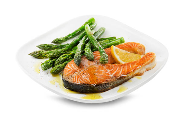 Fresh boiled Asparagus and baked salmon steak with dressing sauce on plate