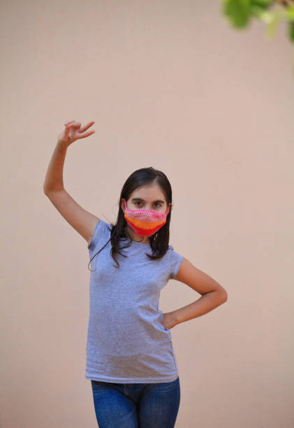 istock Girl with covered face making victory sign 1221227580
