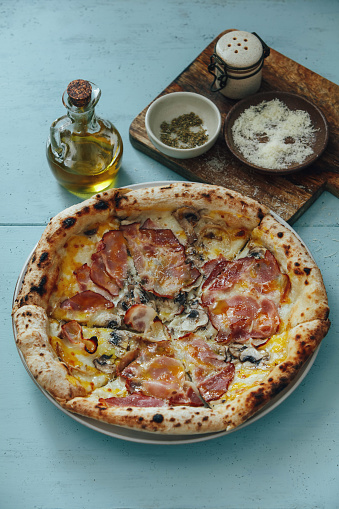 Italian Pizza with Ham and Mushroom on blue background