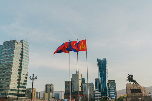 Mongolian flag on the background of Ulaanbaatar cityscape