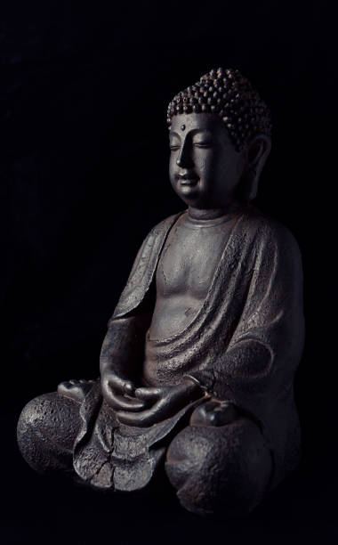 istock Meditating Buddha Statue isolated on black background. 1221228493