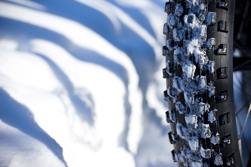 A close up view of the tread of a winter fat bike tire. Fat bikes are mountain bikes with oversized wheels and tires for riding on the snow.