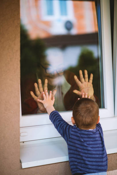 istock Little boy looking at his grandmother at the window 1221230556
