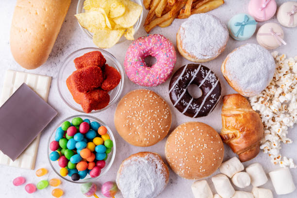 unhealthy food and fast food with donuts, chocolate, burgers and sweets top view - trans fats imagens e fotografias de stock