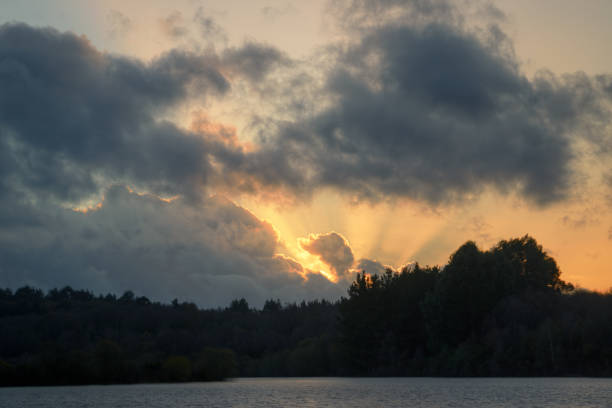 istock Sunset twilight rays pierce cumulonimbus clouds 1221232373