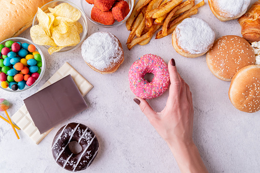 Comida poco saludable y comida rápida con rosquillas, chocolate, hamburguesas y dulces vista superior photo
