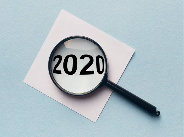 istock 2020 text through magnifier loupe on white sticker on blue background 1221236348
