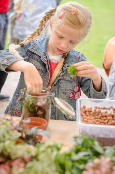 istock active child filling empty glass with soil and plants 1221236796