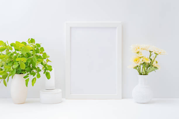 istock Home interior with decor elements. Mockup with a white frame and flowers in a vase on a light background 1221238979