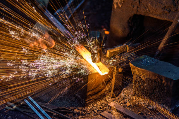 istock Blacksmith manually forging the molten metal on the anvil with spark fireworks 1221240452