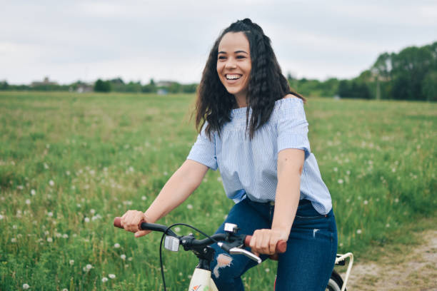 istock Young woman riding a bicycle through a field 1221240582