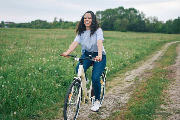 istock Young woman riding a bicycle through a field 1221240628