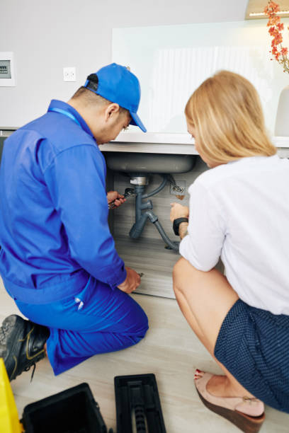 istock Woman showing repairman leaky drain 1221240834