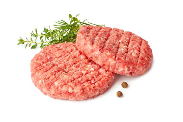 Two raw burger patties with thyme and reosemary on white Two raw burger patties with thyme and reosemary isolated on white background. Clipping path included ground beef photos stock pictures, royalty-free photos & images