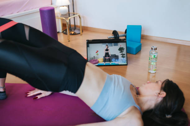 istock Young woman working out, doing online training during lockdown 1221242177
