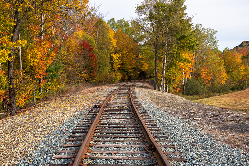 Stunning autumn colours along a deserted railway track in the countryside of New Hampshire at sunset