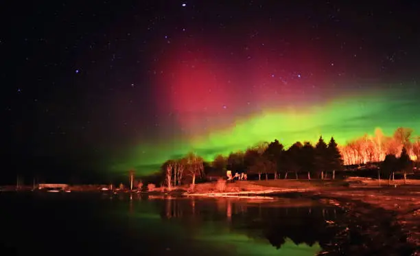 Aurora borealis and stars including Venus lightening up the sky and beach in Georgian Bay, Ontairo, Canada. Cree people consider the Northern Light as dancing spirits.