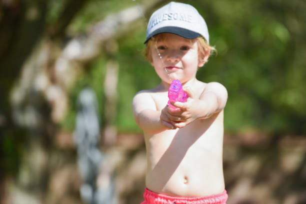 Boy with water pistol playing outside on a sunny day