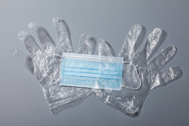 istock Disposable plastic protective gloves and medical protective mask on gray background, close-up shot, Prevention of infection with coronavirus COVID-19 or SARS-CoV-2 obligation to shop shopping 1221249973