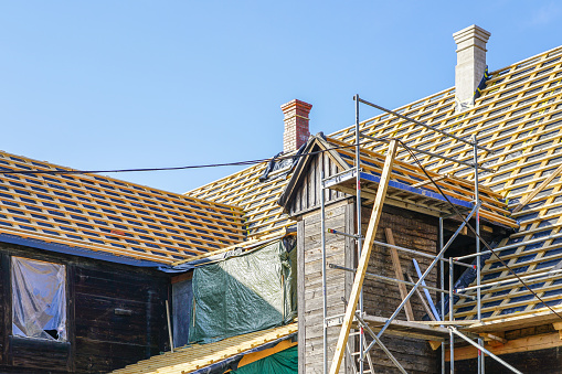 reparación de las estructuras del techo de una casa histórica de madera y la sustitución de baldosas de arcilla photo