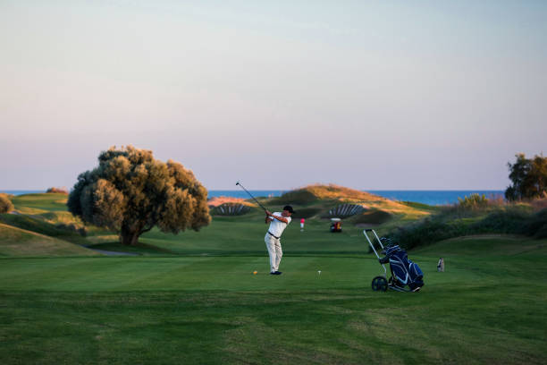istock Golf player gets into position to hit the ball for stroke 1221255943