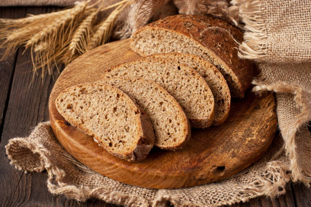 istock Delicious rye  bread with crispy crust  on wooden board 1221256050