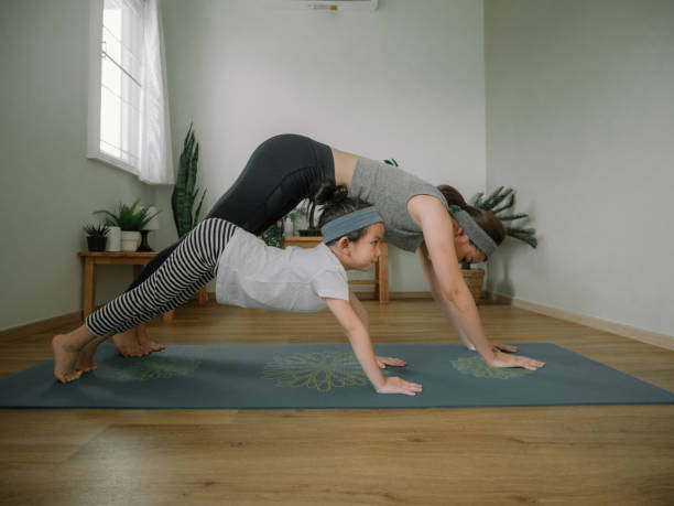 istock Mother and daughter doing yoga 1221256331
