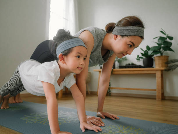 istock Mother and daughter doing yoga 1221256347
