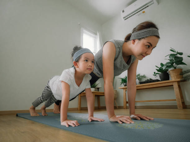 istock Mother and daughter doing yoga 1221256355