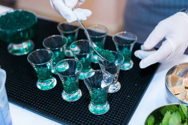 making a green caviar shot at molecular bar drink stock photo