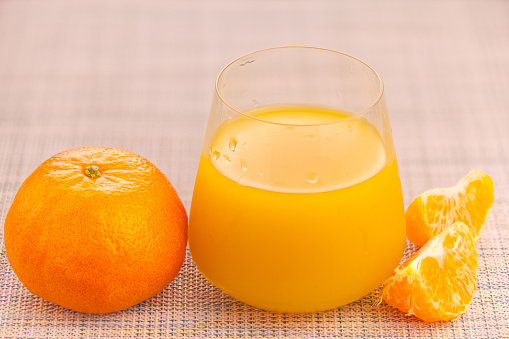 Delicious fresh squeezed tangerine juice in a transparent glass