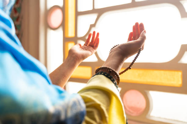 Muslim woman in headscarf and hijab prays with her hands up in air in mosque.Religion praying concept. ramadan stock photo
