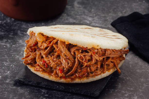 istock Arepa stuffed with shredded meat on a dark background. (Arepa con carne mechada) 1221262028