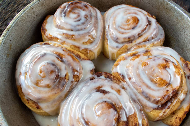 istock baked cinnamon rolls drizzled with white sugar glaze in pan 1221262044