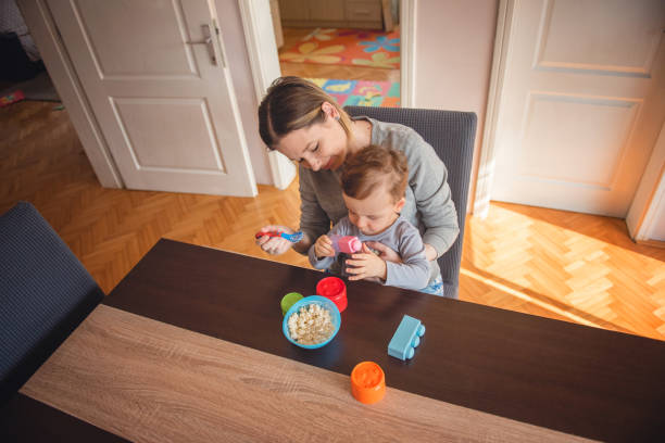 istock Single mother feeding toddler mac and cheese 1221262158