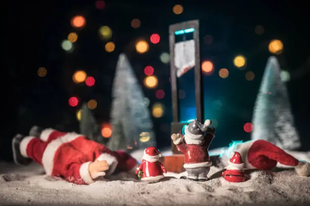 Funny New Year concept. Santa claus and horror guillotine on snow. Tired Santa or stressed santa concept.