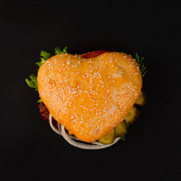 hamburger a forma di cuore su nero - meat beef love heart shape foto e immagini stock