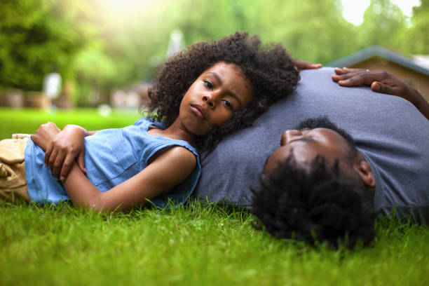 istock African-American son and father lie down on grass at backyard 1221266218