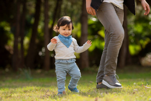 istock Father helping baby boy to practice walking at the backyard 1221269383