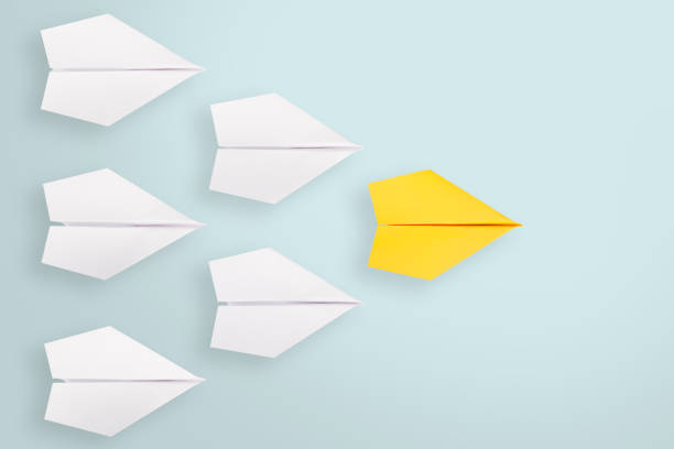 istock Leadership concepts with orange paper airplanes leading among white 1221270382